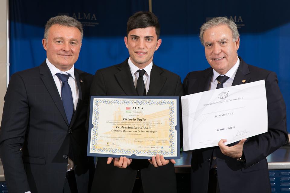 Vittorio Sofia (al centro) con il diploma di professionista di sala rilasciato da Alma, la Scuola Internazionale di Cucina Italiana fondata nel 2004 da Gualtiero Marchesi