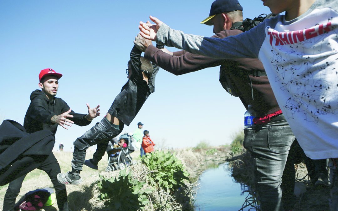 Migranti attraversano il fiume Rio Grande negli USA da Ciudad Juarez, in Messico, dopo l’incendio nel centro di raccolta