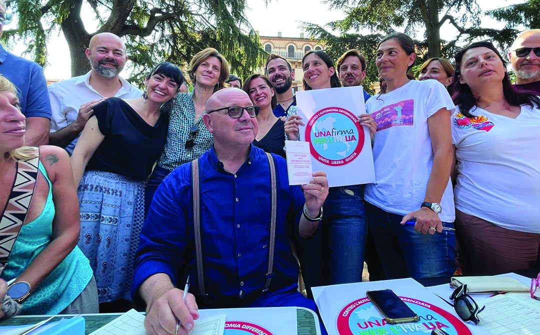 La segretaria del Pd, Elly Schlein, davanti a un banco di raccolta firme contro l’autonomia differenziata